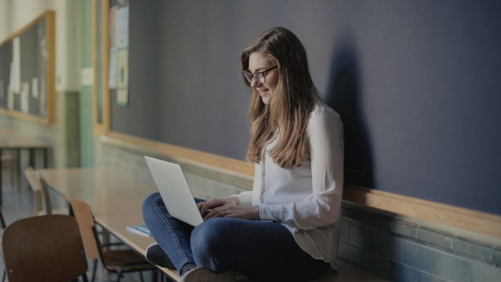 "A focused girl studying with a laptop, staying motivated for study in a peaceful environment."